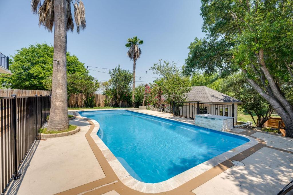 a swimming pool with a fence and a palm tree at Luxe San Antonio Vacation Rental with Private Pool! in San Antonio