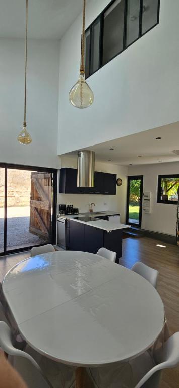 a kitchen with a white table and chairs at Au séchoir à Tabac in Bergerac