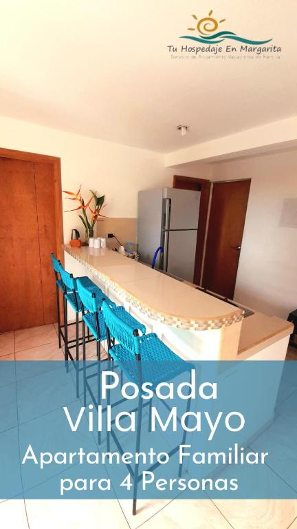 Posada Villa Mayo Apartamento Familiar a 5 Min de Playa Parguito في Paraguachi: مطبخ مع طاولة وكراسي وثلاجة