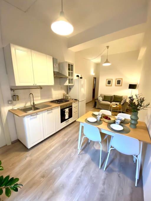 cocina y sala de estar con mesa y sillas en Appartamento vicino al mare- IL GIACINTO, en Civitanova Marche