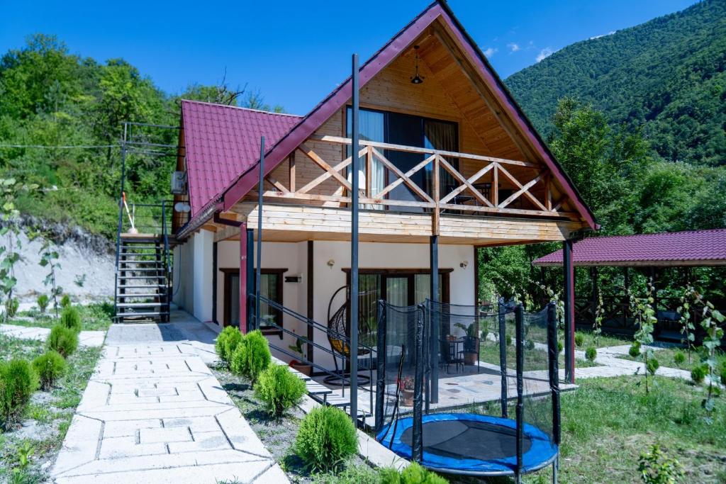 una casa con un aro de baloncesto delante de ella en Forest Side Gogolati, en Ambrolauri