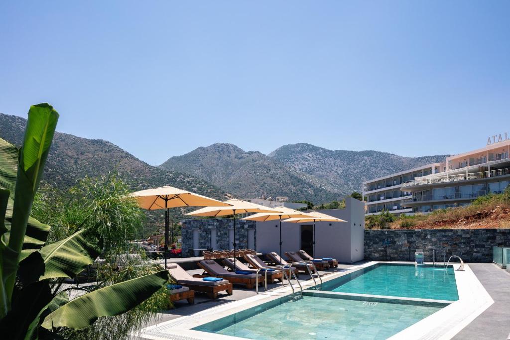 a hotel with a swimming pool and mountains in the background at Isla Villas & Suites in Balíon