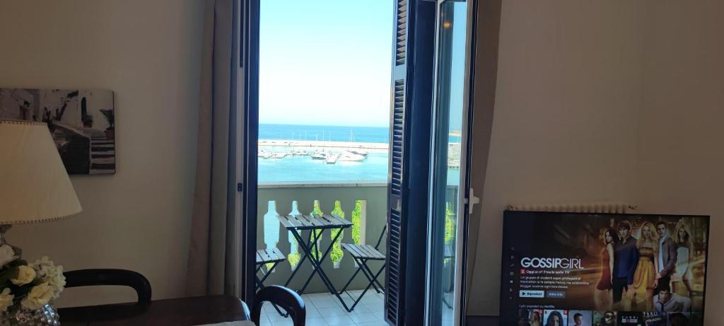 een kamer met uitzicht op de oceaan door een glazen deur bij Adua Exclusive Suite in Bari