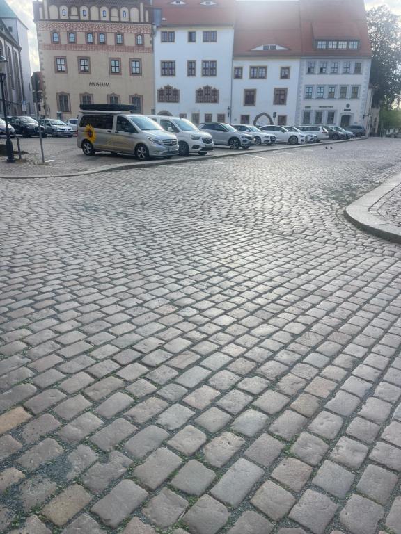 a cobblestone street with cars parked in a parking lot at Donatsgasse18 in Freiberg