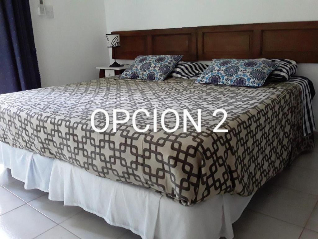 a bed with a comforter with the word opion on it at El Balcón 2 in Concepción del Uruguay