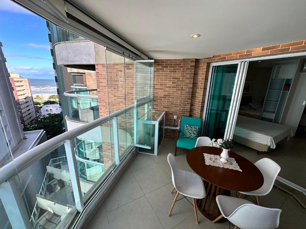 a balcony with a table and chairs and a bed at Residencial Estanconfor com Vista Mar 3 AC Garagem in Santos