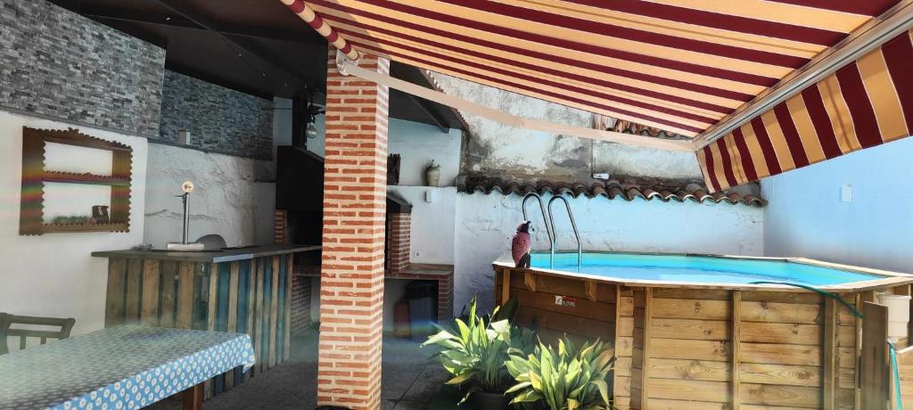 a patio with a hot tub under a canopy at Casa Rural Abuela Andrea in Almonacid de Toledo