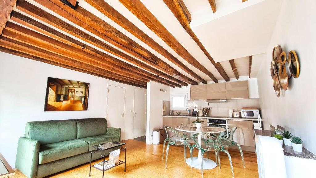 a living room with a couch and a table at Casalionelparis : Your home in the heart of Paris in Paris