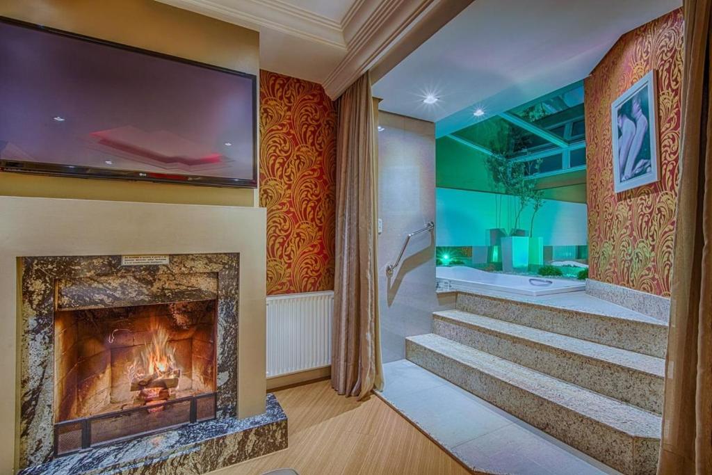 a living room with a fireplace and a tv at Ettus in Caxias do Sul