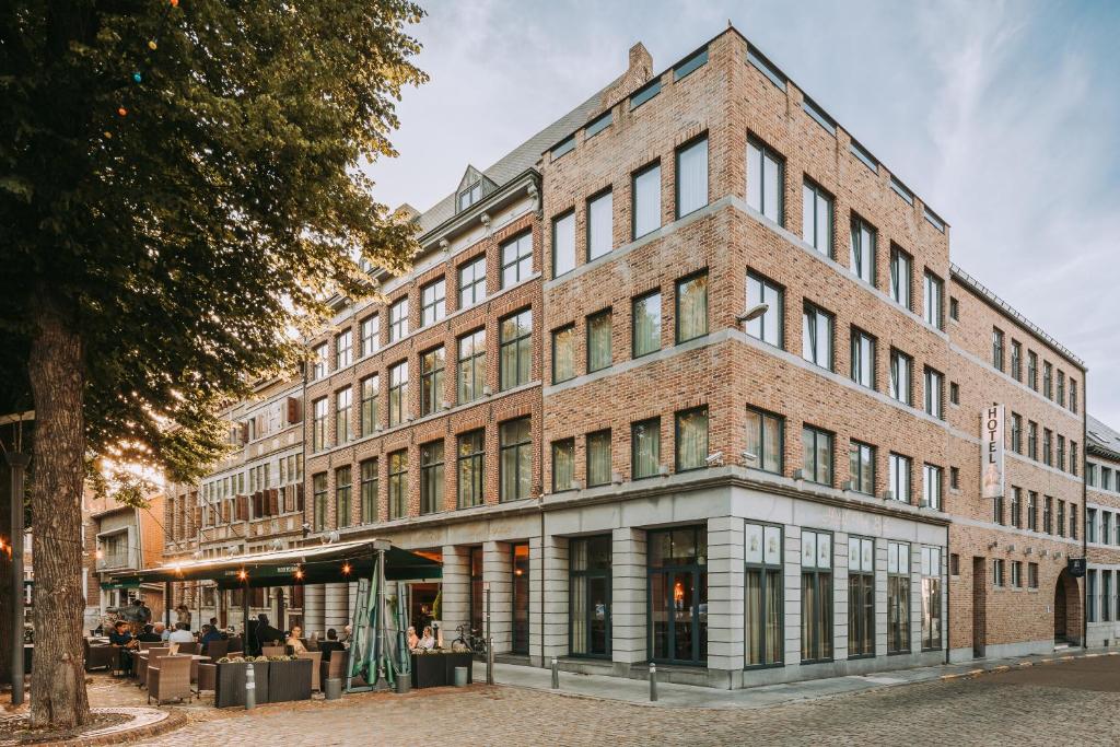 a large brick building on a city street at Hotel Van Eyck in Maaseik