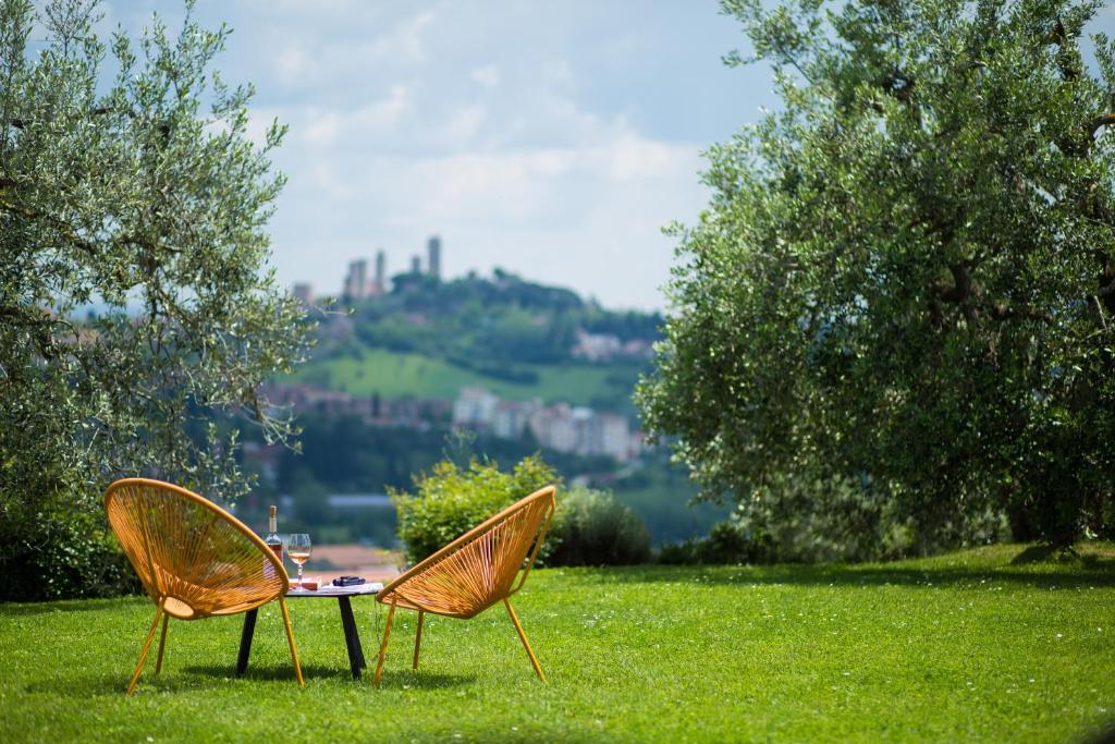 twee stoelen en een tafel in het gras bij Poggetto di Montese in San Gimignano