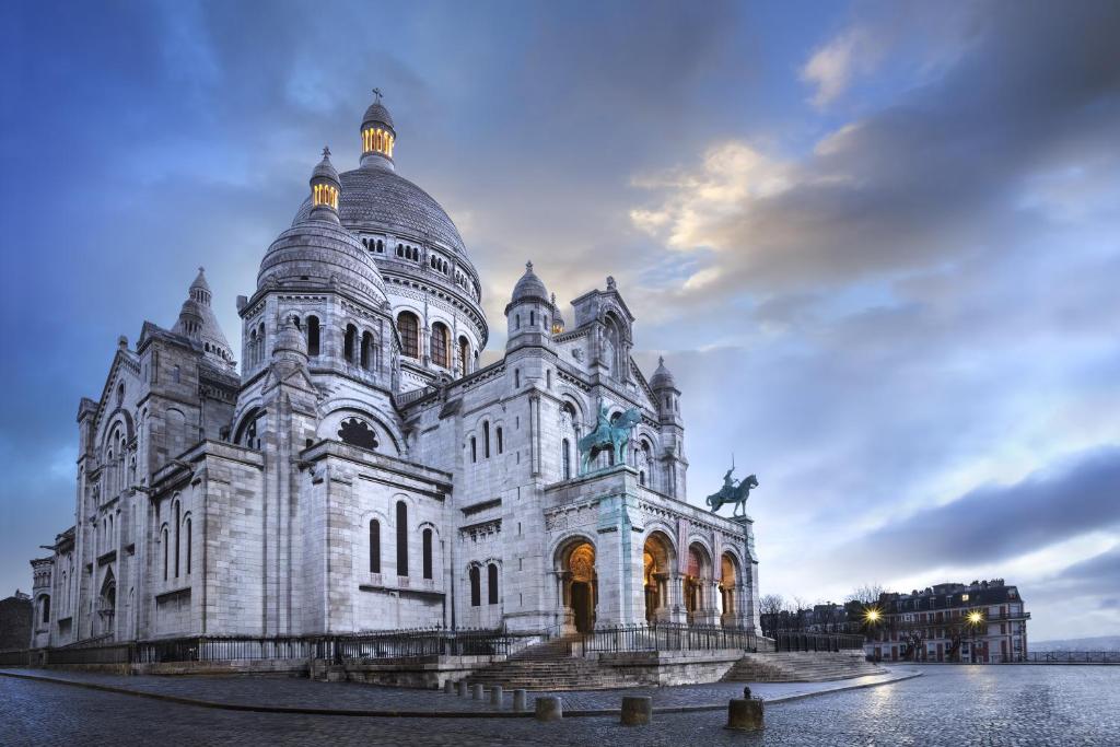 un gran edificio blanco con un cielo en el fondo en Appartement A deux pas de Montmartre, en París