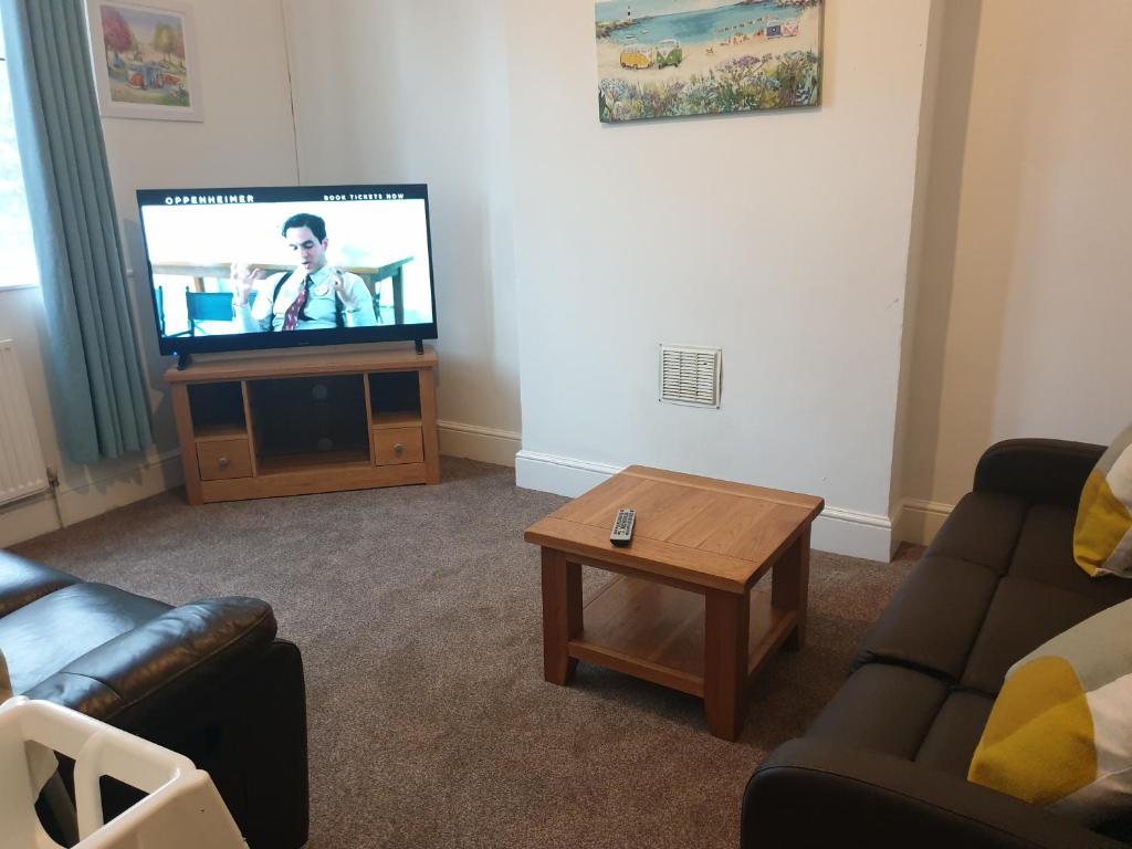 a living room with a flat screen tv and a coffee table at Large first floor flat walking distance to beach in Weston-super-Mare