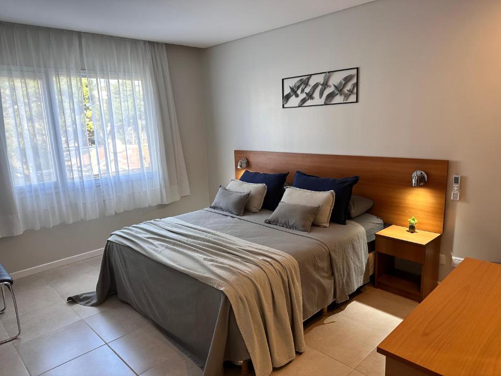 um quarto com uma cama grande e almofadas azuis em Suite del sol 119 em Pinamar