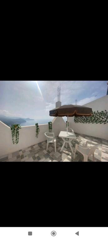 un patio con mesa, sillas y sombrilla en Spacious 2 bedrooms apartment, en Alhucemas