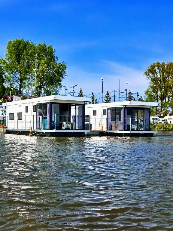two houses on a boat on the water at ARKA 2 domki na wodzie w Mielnie 400 metrów do morza, rower wodny, Wifi, Parking in Mielno
