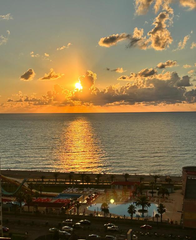 a sunset over the ocean with the sun setting at Black Sea Apartament in Batumi