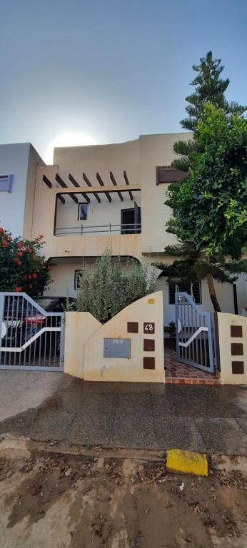 un bâtiment avec une porte et un arbre devant lui dans l'établissement Mini villa, à Saïdia