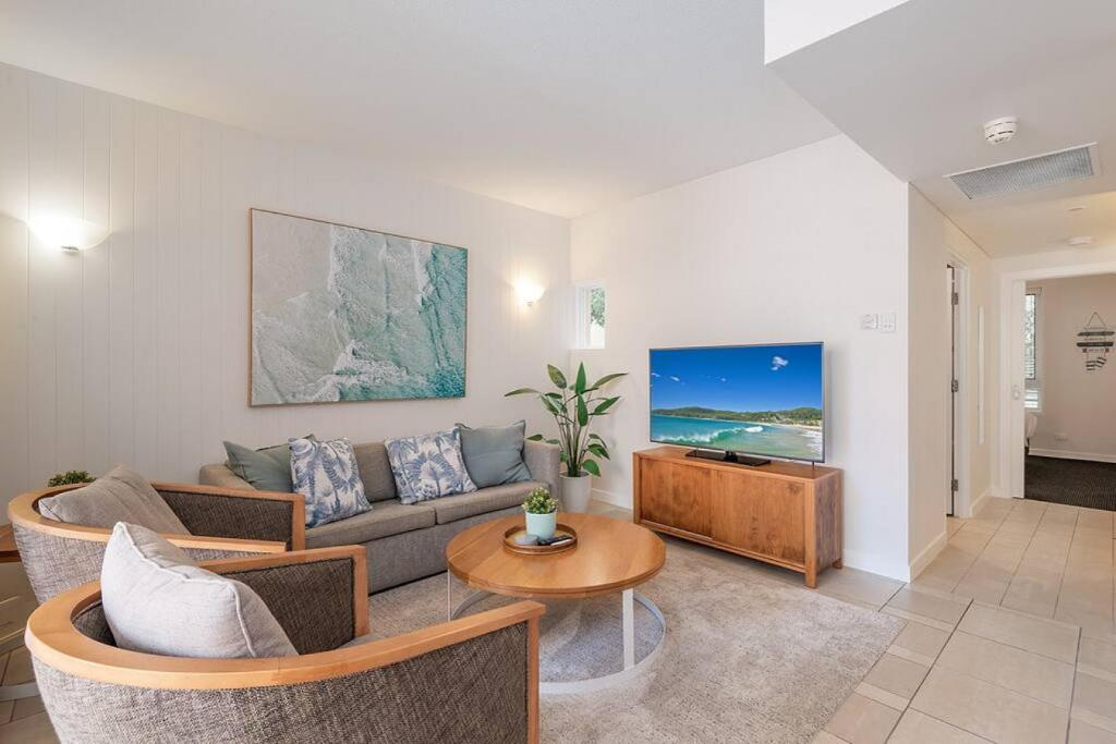 a living room with a couch and a table at Poolside luxury on Hastings St 212 in Noosa Heads