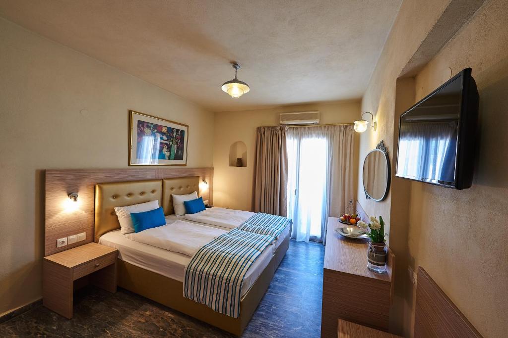 a hotel room with a bed and a television at Thalia deco City & Beach Hotel in Hersonissos