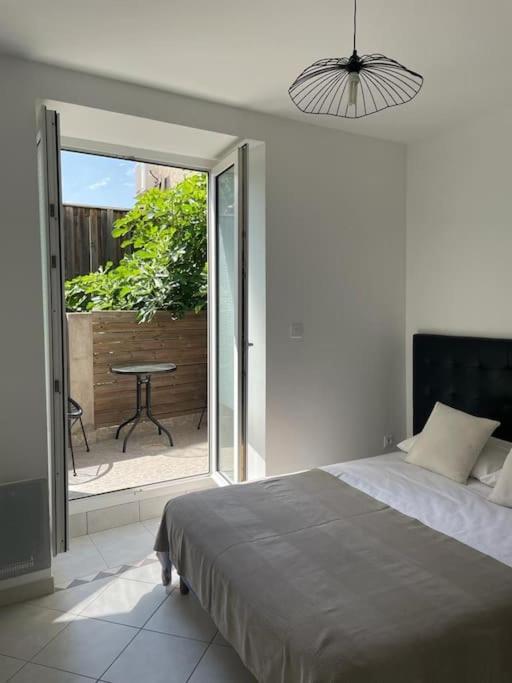 - une chambre avec un lit et une terrasse avec une table dans l'établissement maison lumineuse, à Villemoustaussou