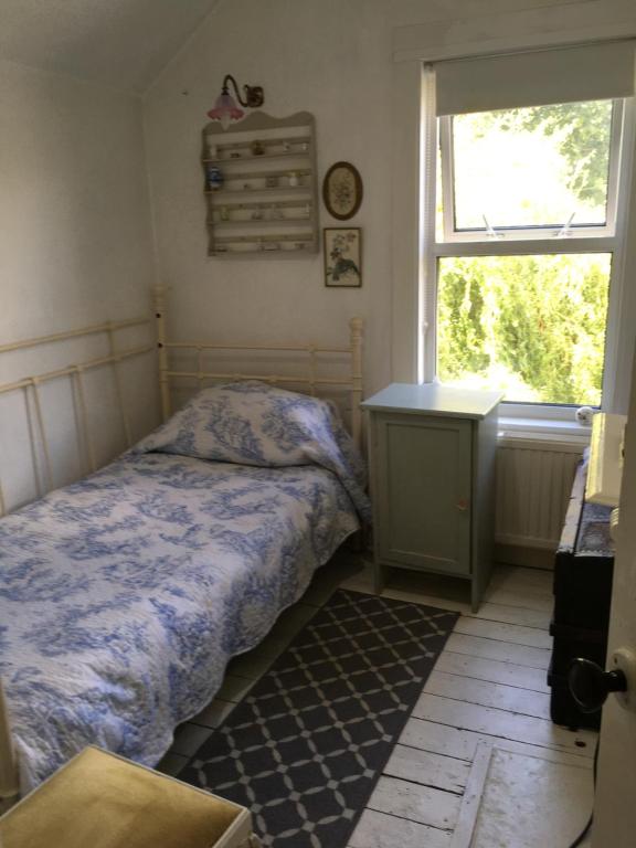 1 dormitorio con cama, escritorio y ventana en Arts&BichonsB&B, en Oxford