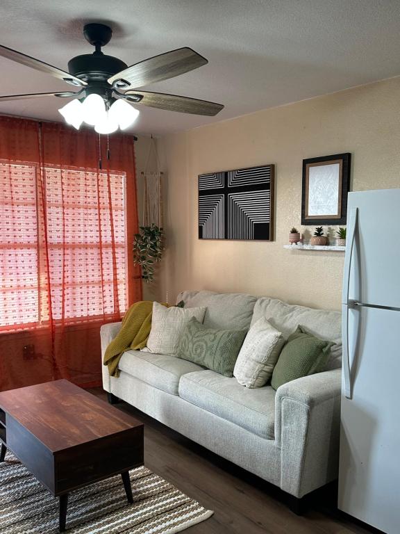 a living room with a couch and a ceiling fan at The Sinaí Apartment is Cozy Place in Eagle Pass