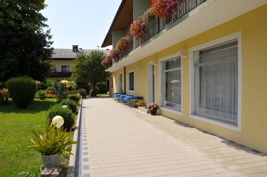 a walkway next to a building with flowers on it at Pension Miklautz in Sankt Kanzian