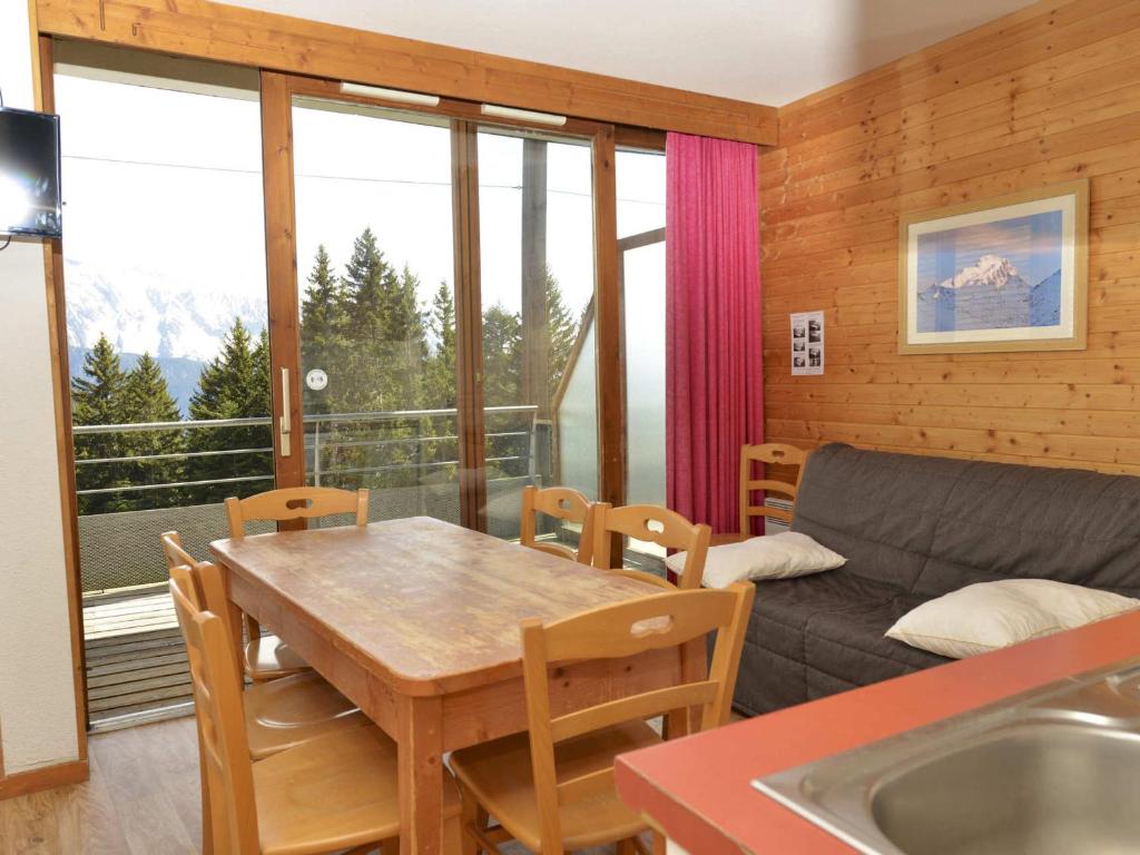 ein Wohnzimmer mit einem Tisch und einem Sofa in der Unterkunft Appartement Chamrousse, 3 pièces, 6 personnes - FR-1-549-78 in Chamrousse