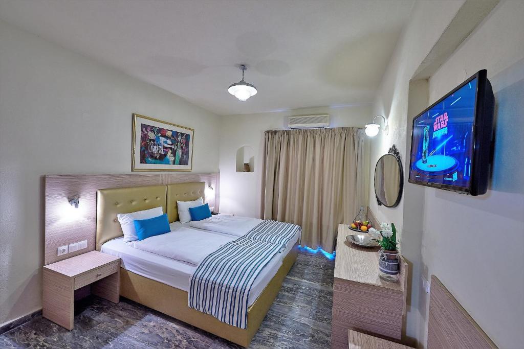a bedroom with a bed and a flat screen tv at Thalia deco City & Beach Hotel in Hersonissos