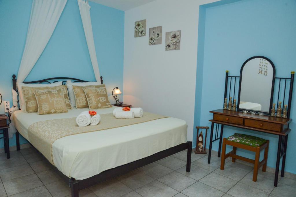 Schlafzimmer mit einem Bett, einem Tisch und einem Spiegel in der Unterkunft nikola's house in Adamas