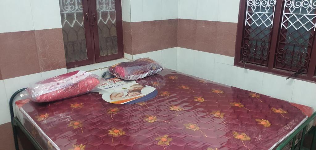 Una cama morada con un perro encima. en Hallima Service Apartments Non Ac Homestay low Budget, en Pudukkottai