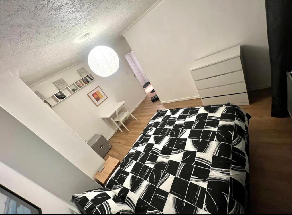 a bedroom with a black and white bed in a room at Whitechapel Rooms R2 in London