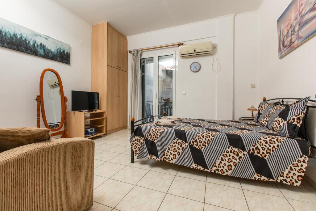 スパルティにあるCentral Cozy Apartmentのベッド、テレビ、ソファのある寝室