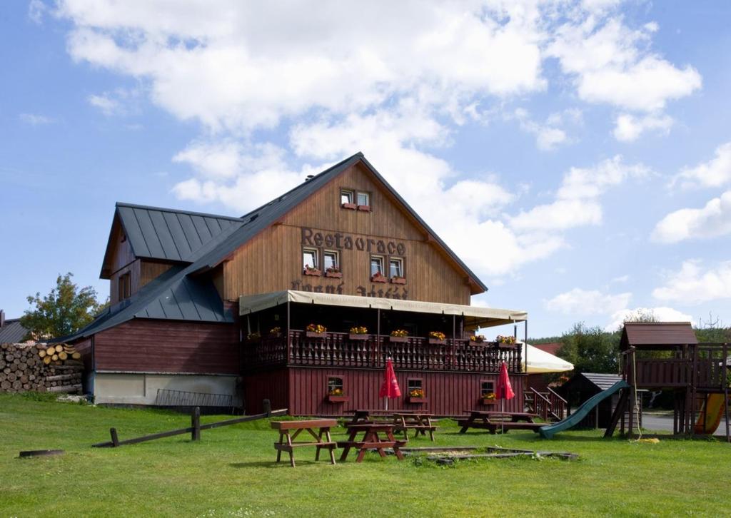 a large building with picnic tables in front of it at Penzion Lesní Zátiší in Horní Malá Úpa