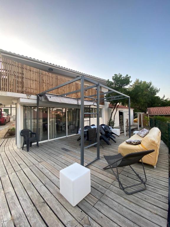 - une terrasse avec un canapé et des chaises dans un bâtiment dans l'établissement APPARTEMENT T3 CAPBRETON SANTOCHA, à Capbreton