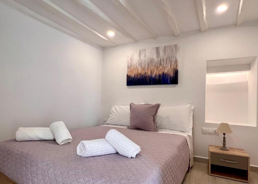 ein Schlafzimmer mit einem Bett mit zwei weißen Kissen in der Unterkunft Camara’s Gem in Poros