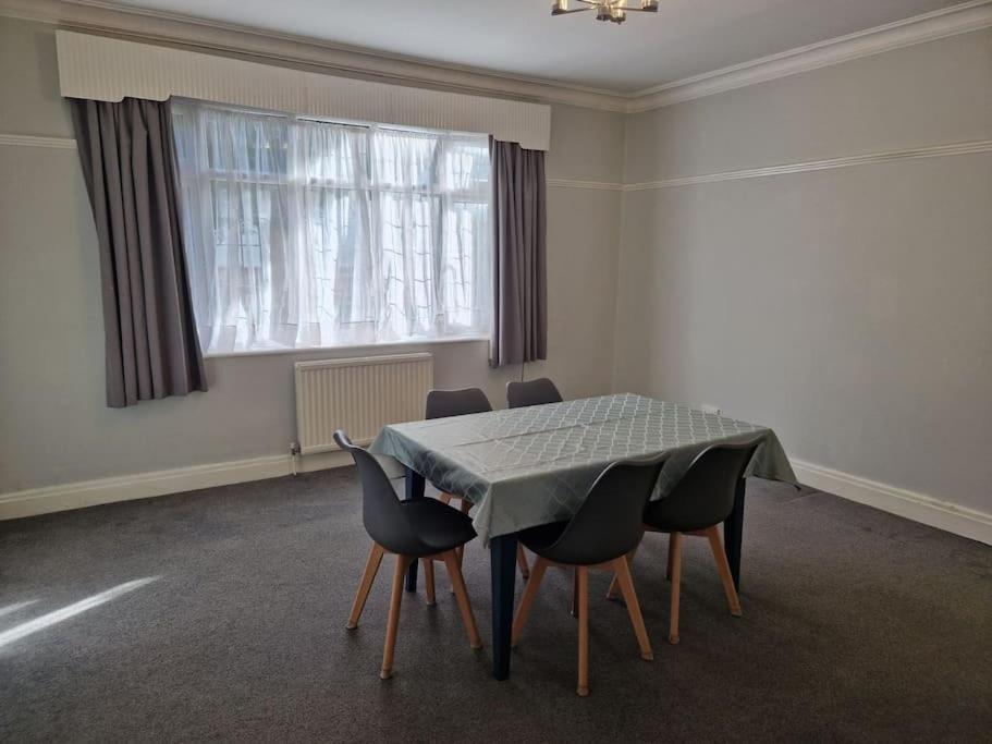 a room with a table with chairs and a window at Modern 3BD London Flat in London