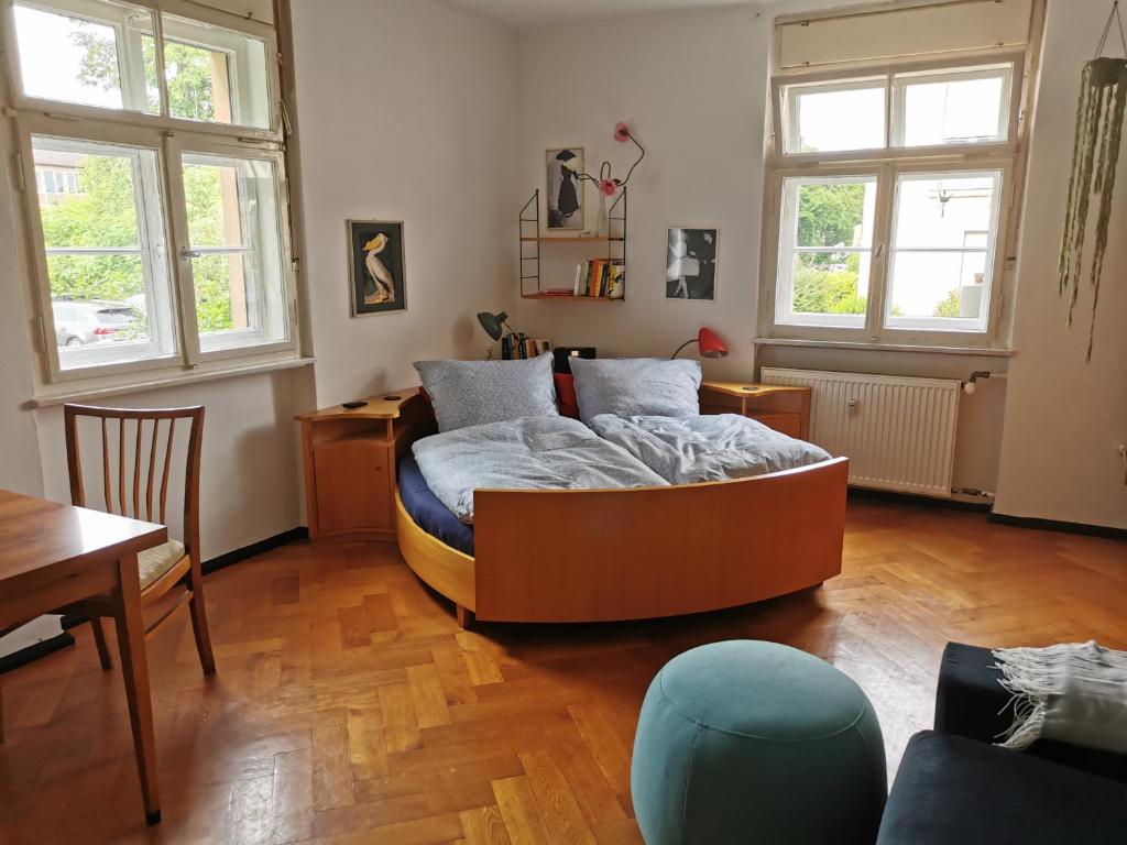 a bedroom with a bed and a desk and windows at Gundis Gästezimmer in Bamberg