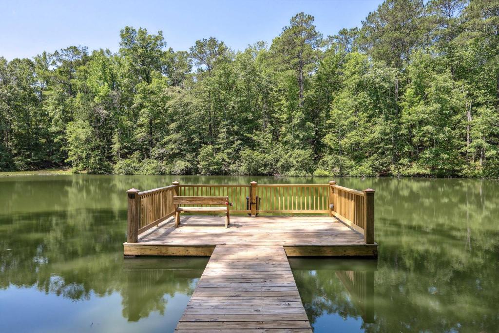 a wooden dock with a bench sitting on top of a lake at Lakefront Hamilton Cabin w/ Dock & Fire Pit! in Hamilton