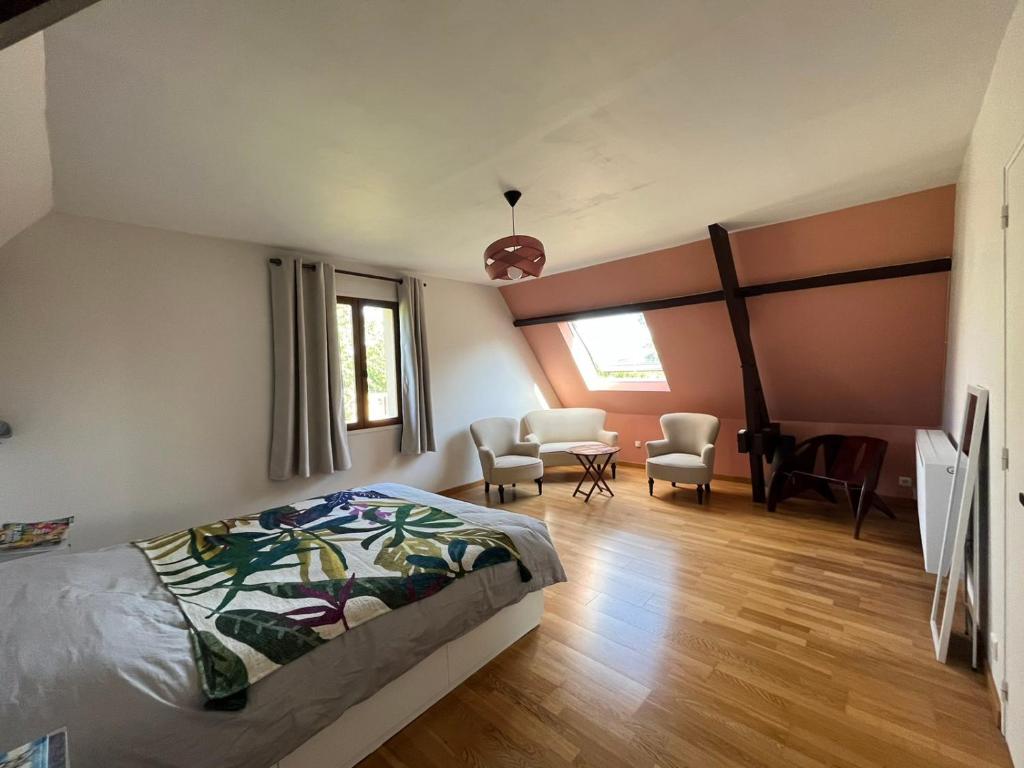 Un dormitorio con una cama y una mesa y sillas. en Le Verger en Auge, en Saint-Léger-sur-Bonneville