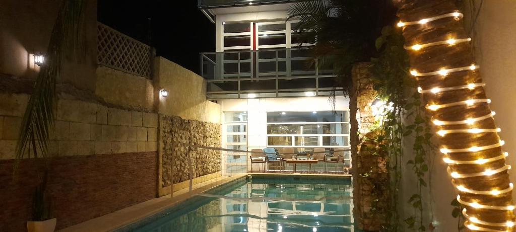 a swimming pool at night with a building in the background at Casa con Piscina Privada Playas del Mar in Cartagena de Indias