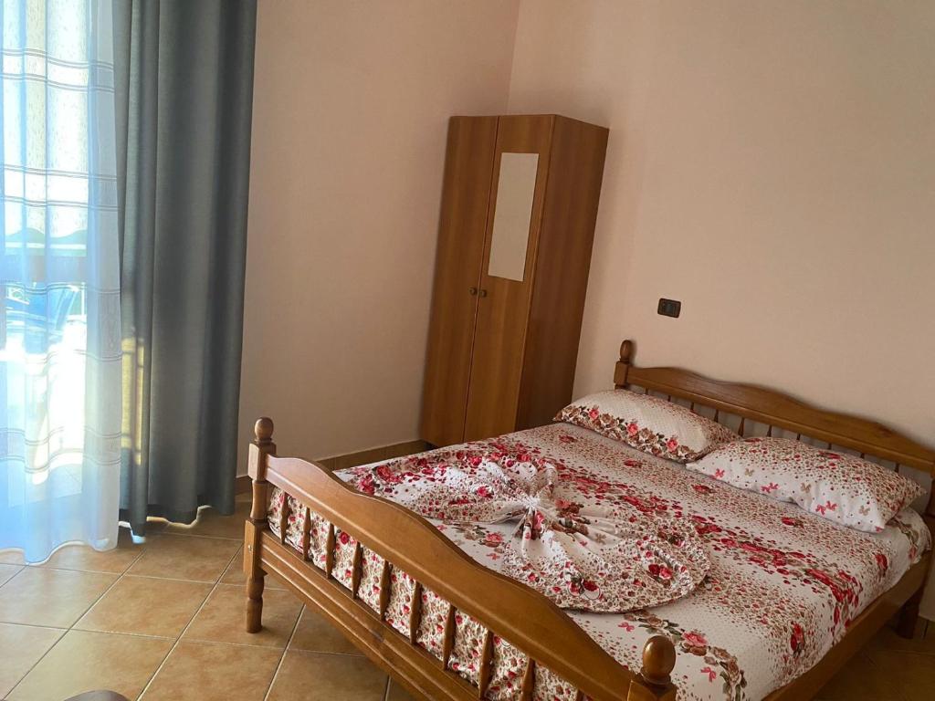 una camera con letto con testiera in legno e finestra di Hotel Egli a Velipojë