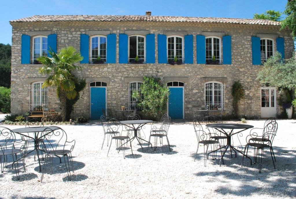um grupo de mesas e cadeiras em frente a um edifício em Bastide De La Lézardière em Fontaine-de-Vaucluse