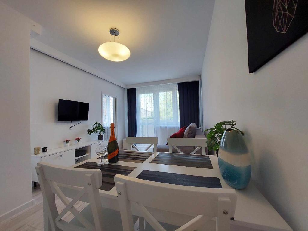 jadalnia ze stołem, krzesłami i telewizorem w obiekcie Albatros Apartment Stogi w Gdańsku