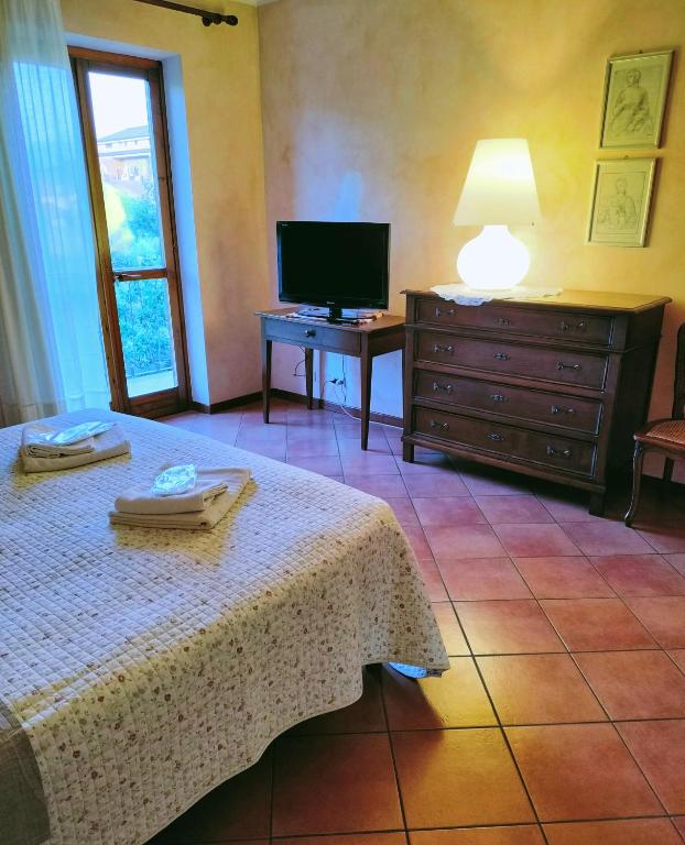 sypialnia z łóżkiem, telewizorem i komodą w obiekcie B&B "Madama Granèt" w mieście Borgo San Dalmazzo