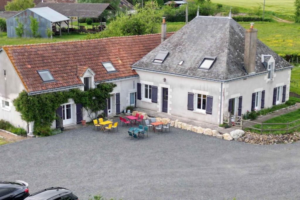 uma vista aérea de uma casa branca com mesas e cadeiras em Au Temps Retrouvé em Nouans-les-Fontaines