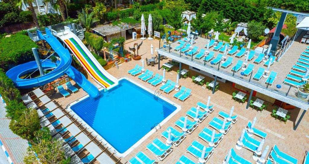een uitzicht op een zwembad met stoelen en een glijbaan bij Club Big Blue Suit Hotel - All Inclusive in Alanya