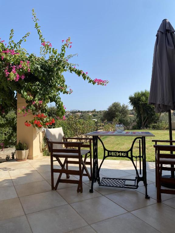 a patio with a table and chairs and an umbrella at House with Garden in Peratata - 10' from City Center in Peratáta