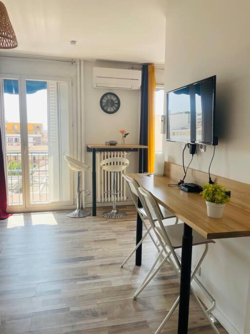 - un salon avec un bureau, une télévision et une table dans l'établissement Petit Studio centre Joliette(1), à Marseille